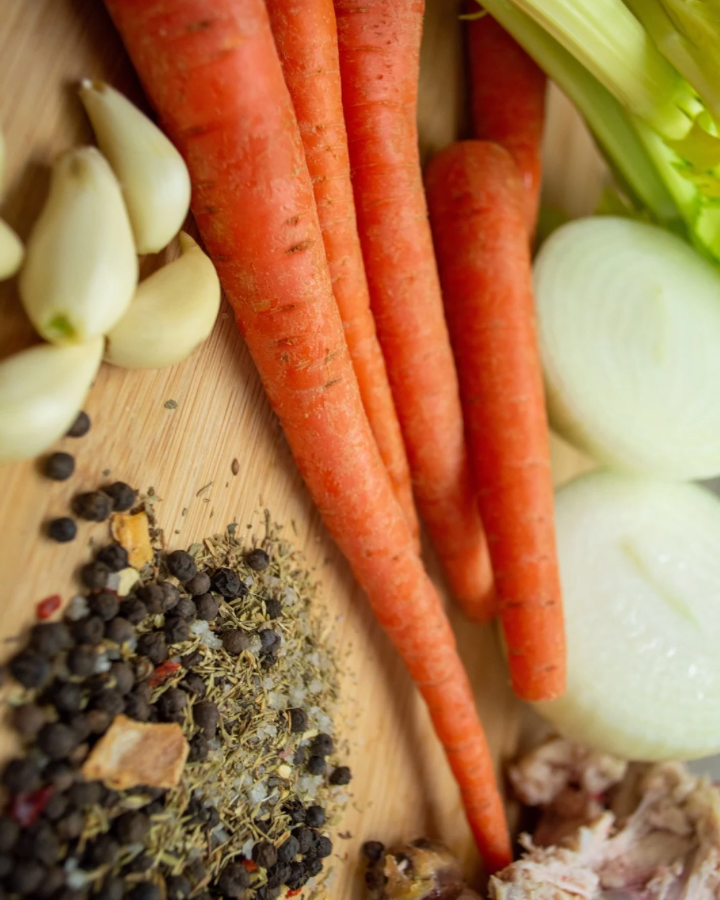 Chicken bone broth ingredients on wooden cutting board