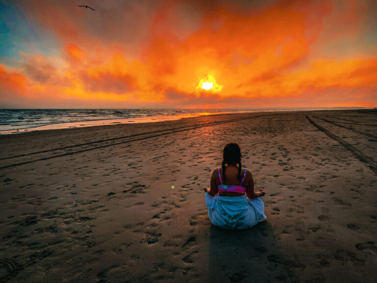 That girl meditating on the beach at sunset
