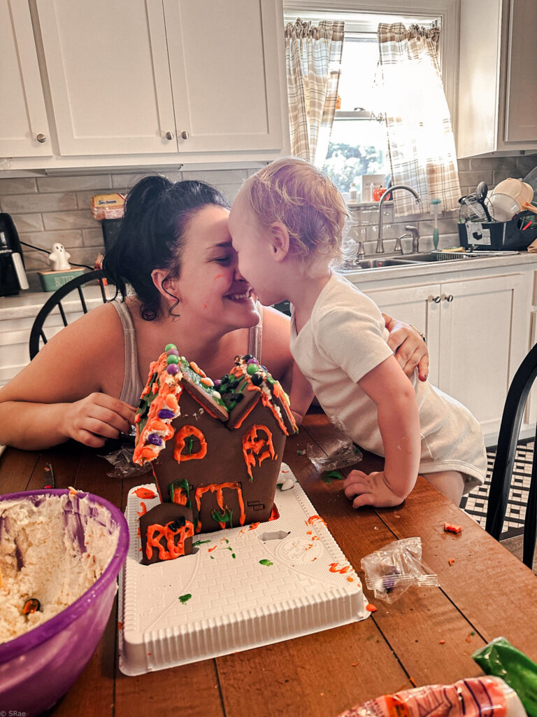 Other and son enjoy a slow living moment nose to nose after building a gingerbread house