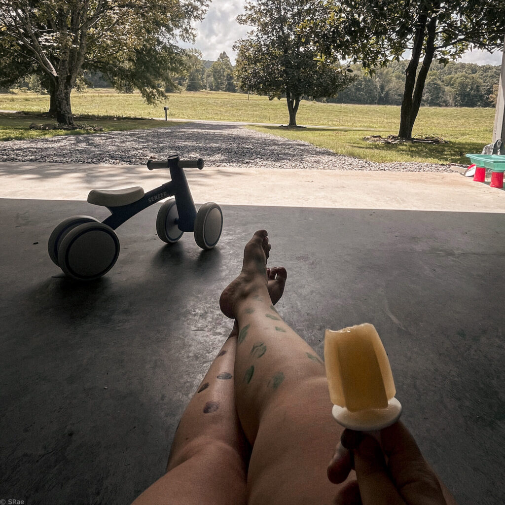 sitting on ground eating a popsicle