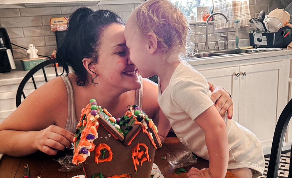 Other and son enjoy a slow living moment nose to nose after building a gingerbread house