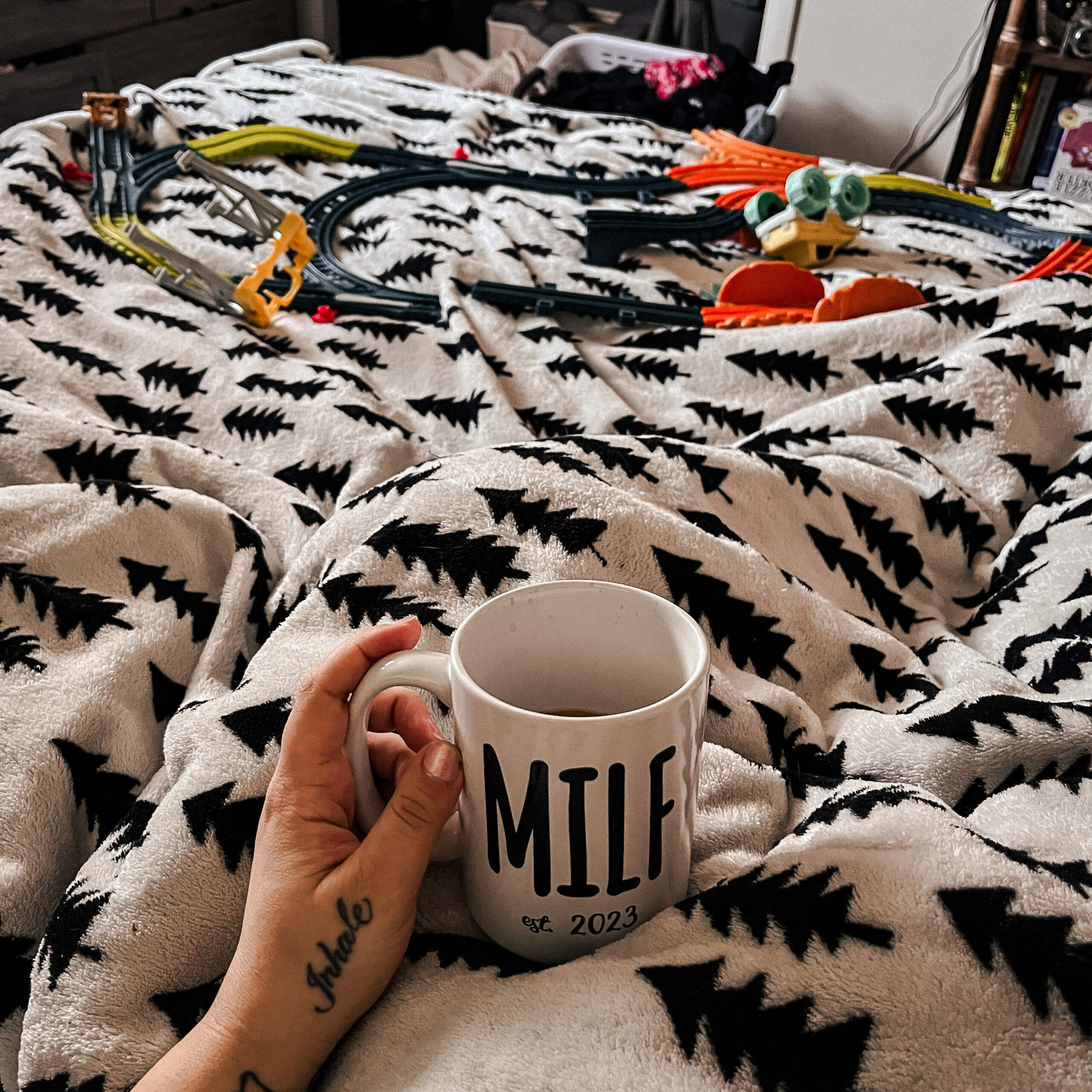 morning rest in bed for mom with coffee and train track in the background