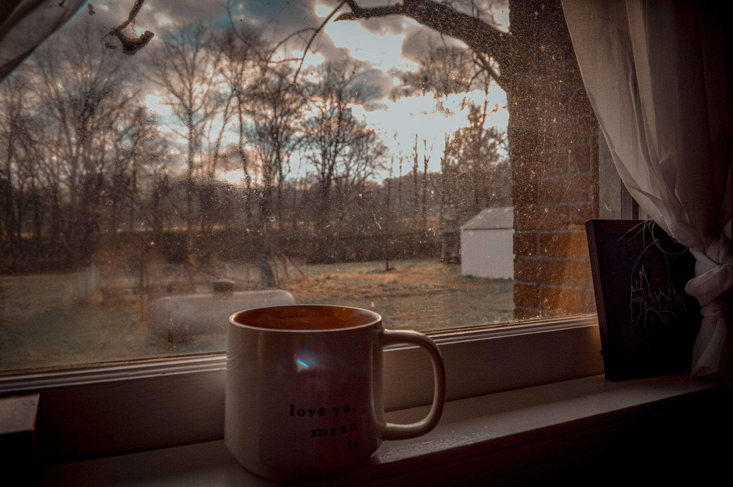 slow sunrise with mug of coffee on the window seal